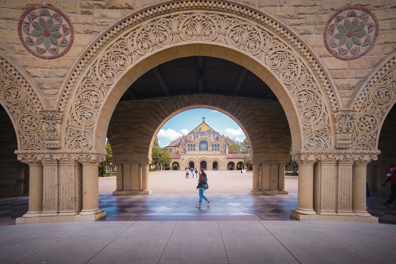 Intricate stone arches at Stanford University framing the scenic campus view.